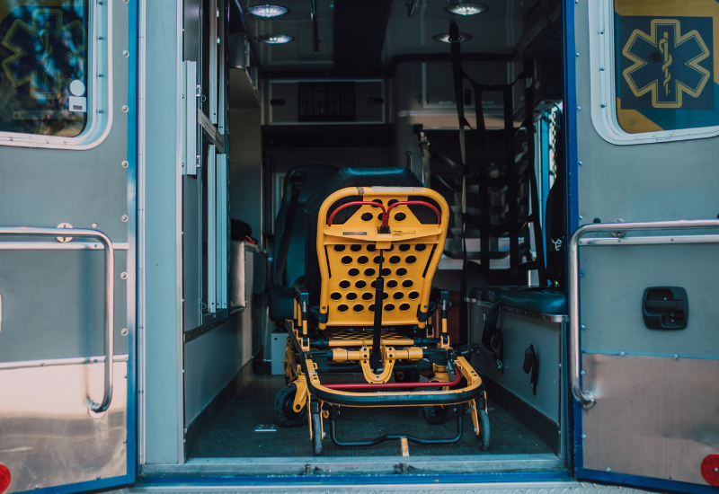 Back of the ambulance is a yellow metal stretcher